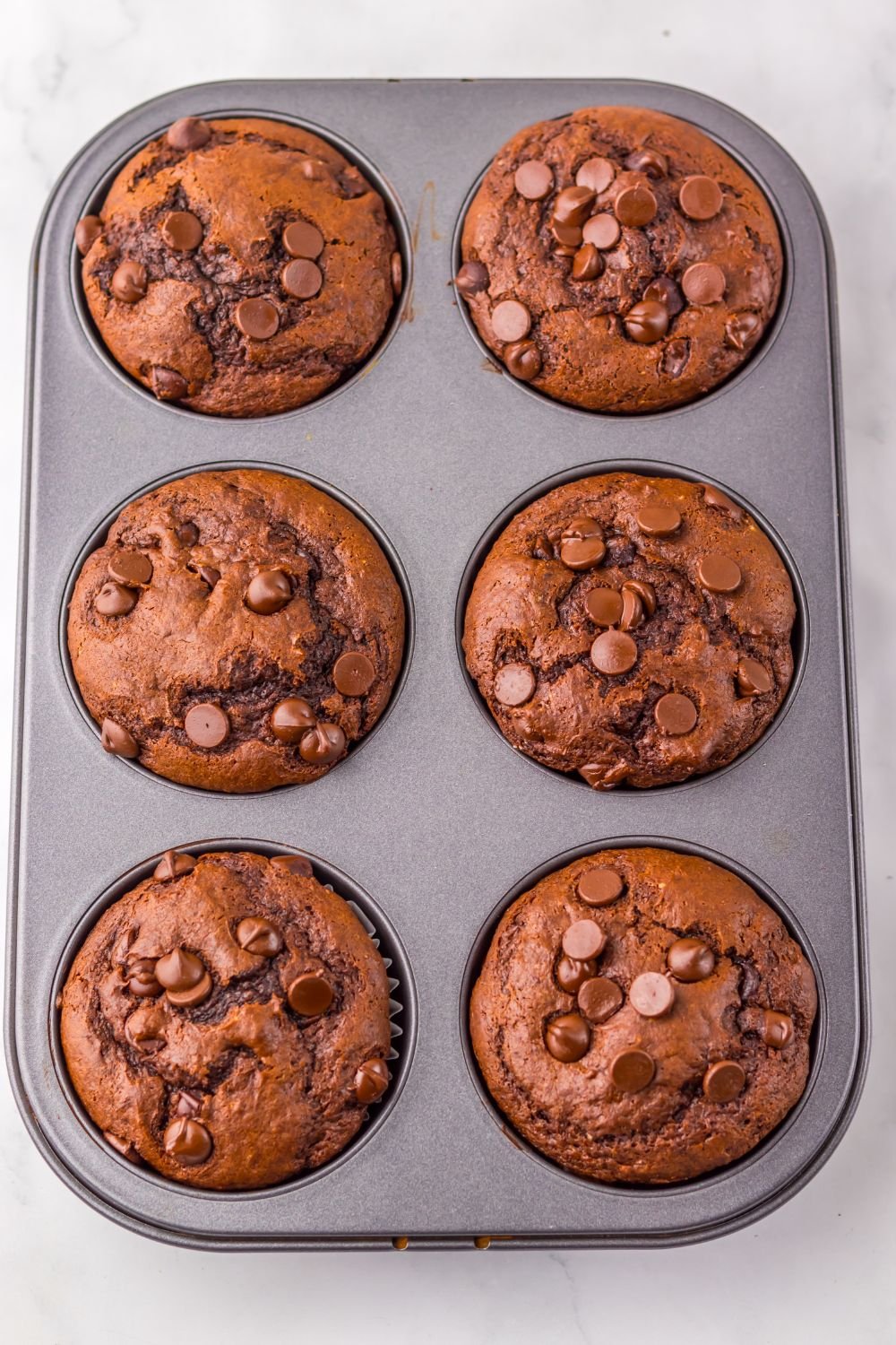 overhead look of muffin tin full of homemade Costco Double Chocolate Muffins