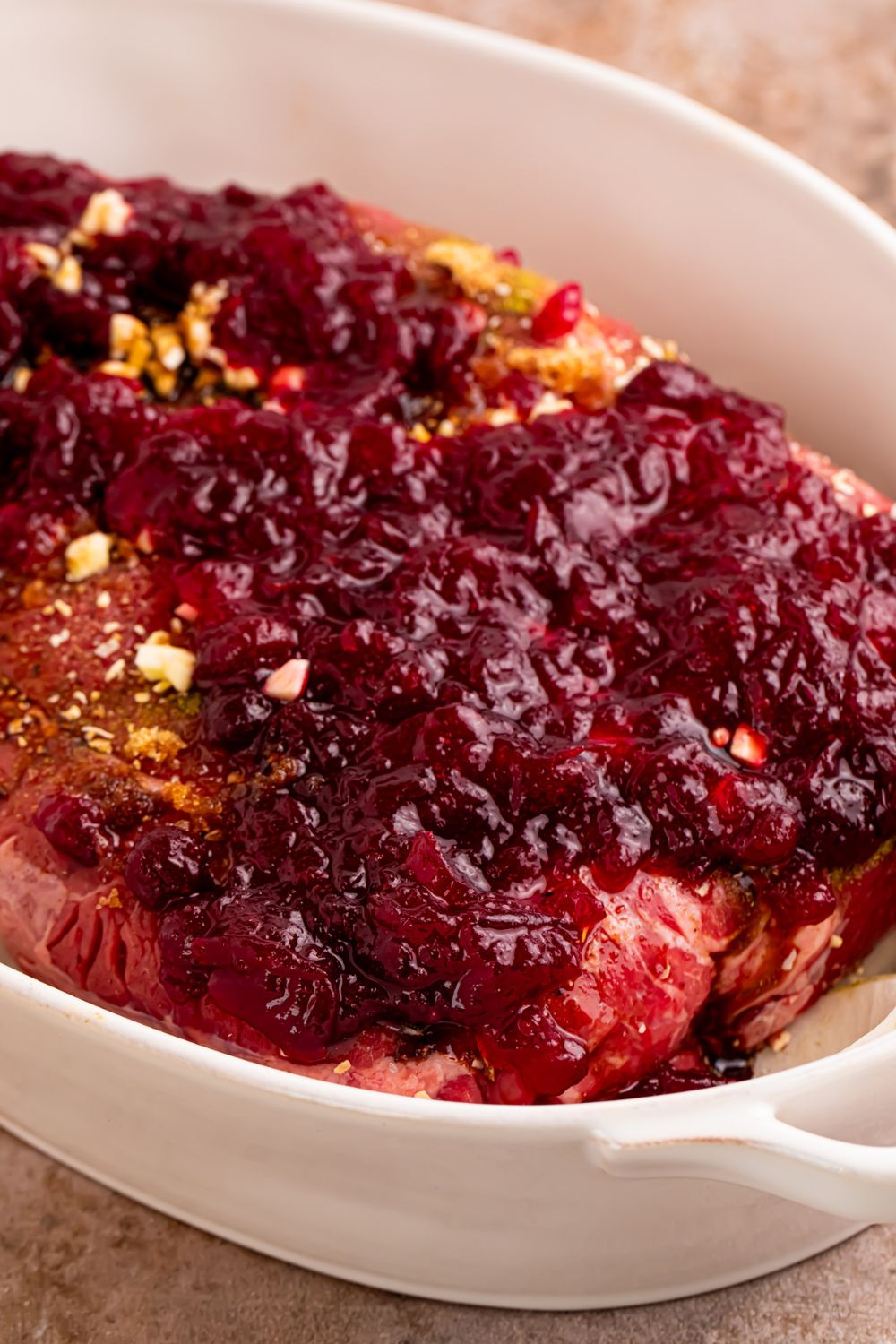 close up of raw Cranberry Pot Roast in pan with cranberry sauce on top 