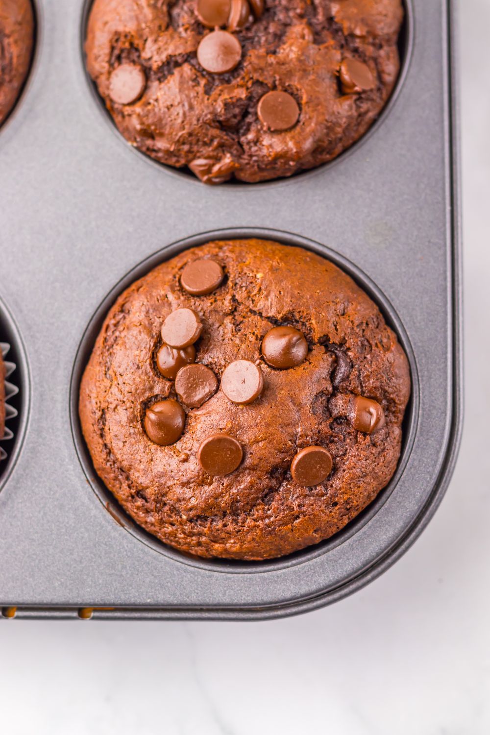 muffin pan with Costco Double Chocolate Muffins in it sitting on table 
