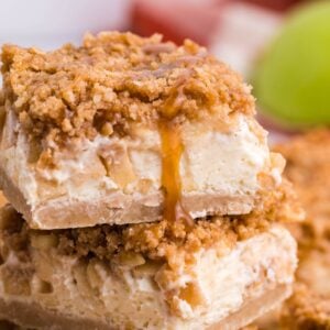 Caramel Apple Cheesecake Bars sliced and stacked on top of one another on table