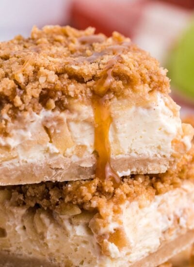 Caramel Apple Cheesecake Bars sliced and stacked on top of one another on table