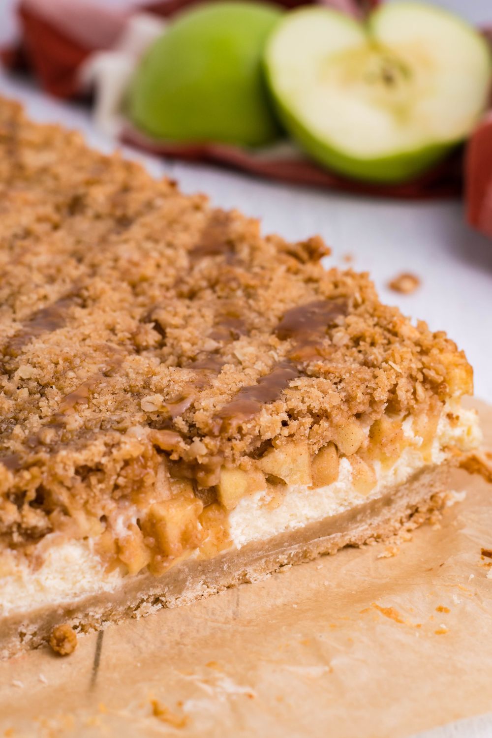 Caramel Apple Cheesecake Bars on table with a few cut off 