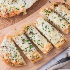 Cheesy Garlic Bread sliced and placed on a cutting board sitting on table