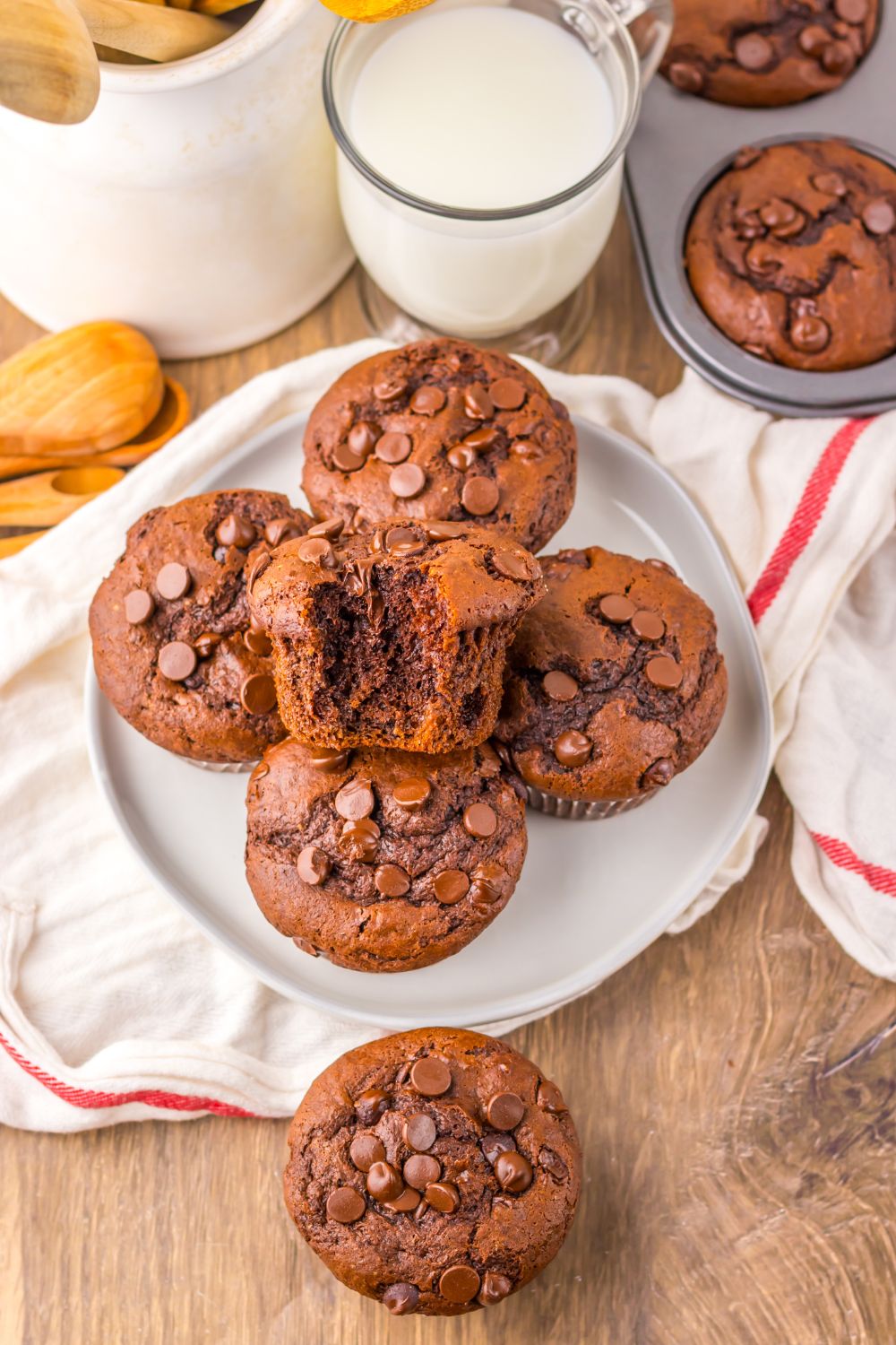 Costco Double Chocolate Muffins around table on a plate, table, and a towel laid out on table 