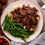 Cranberry Pot Roast on plate with mashed potatoes and fresh green beans and a fork to side on table