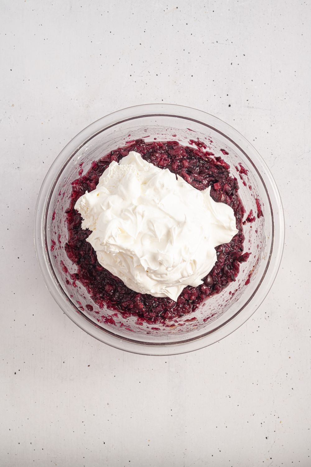 white counter with a cranberry mixture topped with a creamy whipped topping mixture 