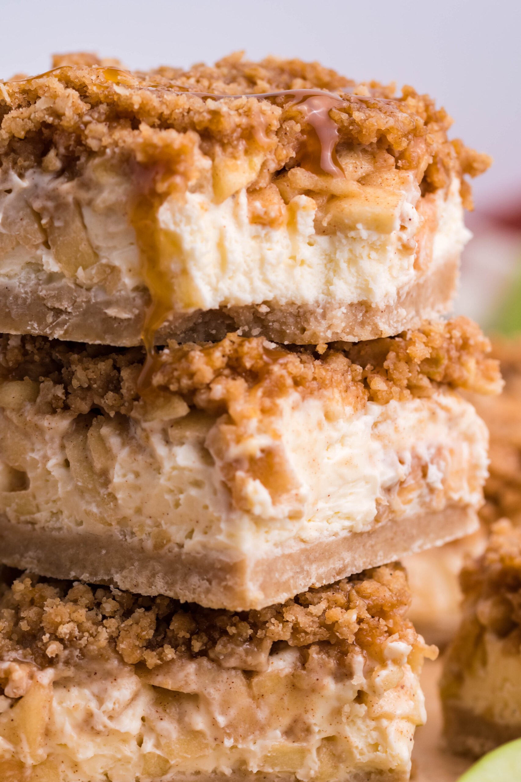 Caramel Apple Cheesecake Bars sliced and stacked on top of one another on a table 