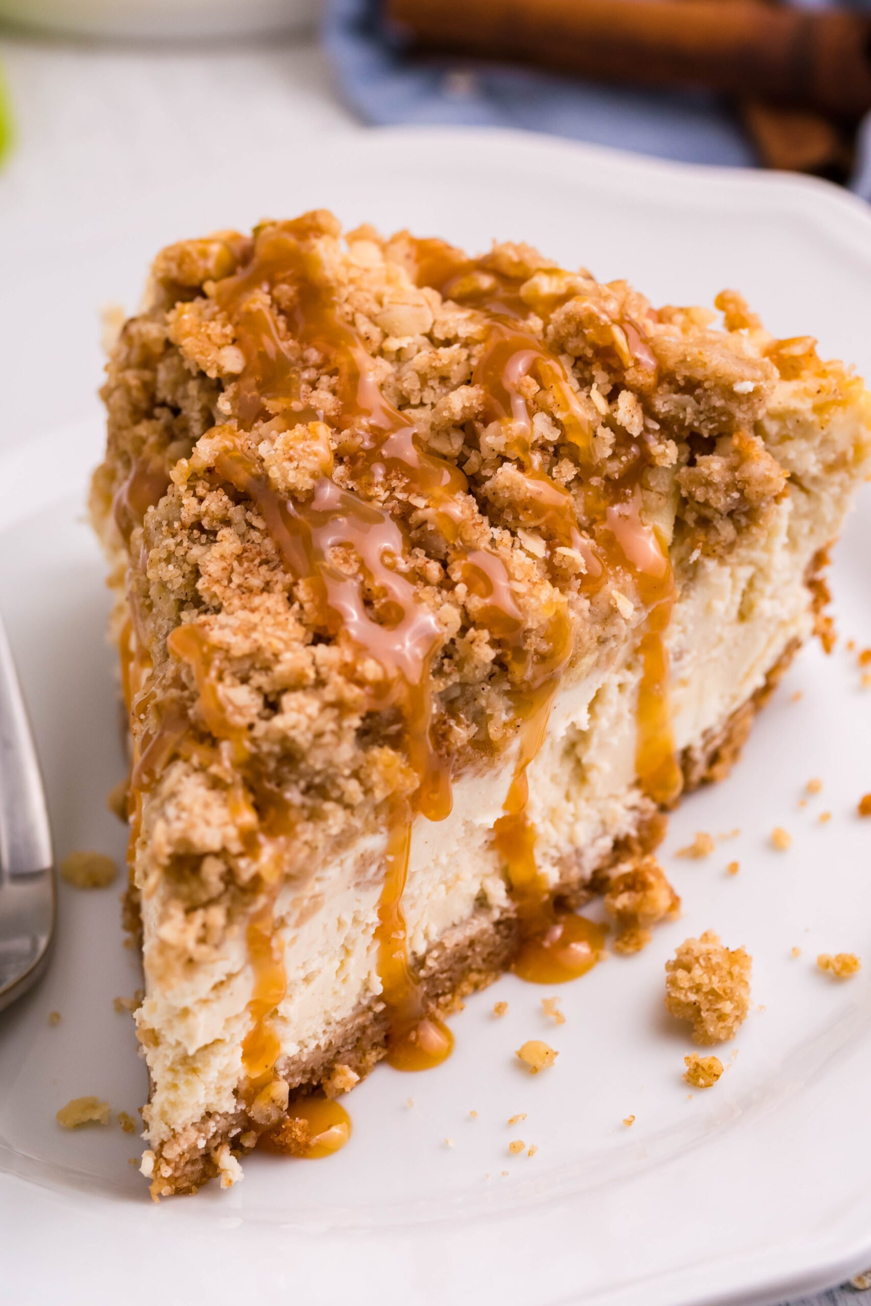 overhead shot of a slice of Caramel Apple Crisp Cheesecake on a white plate