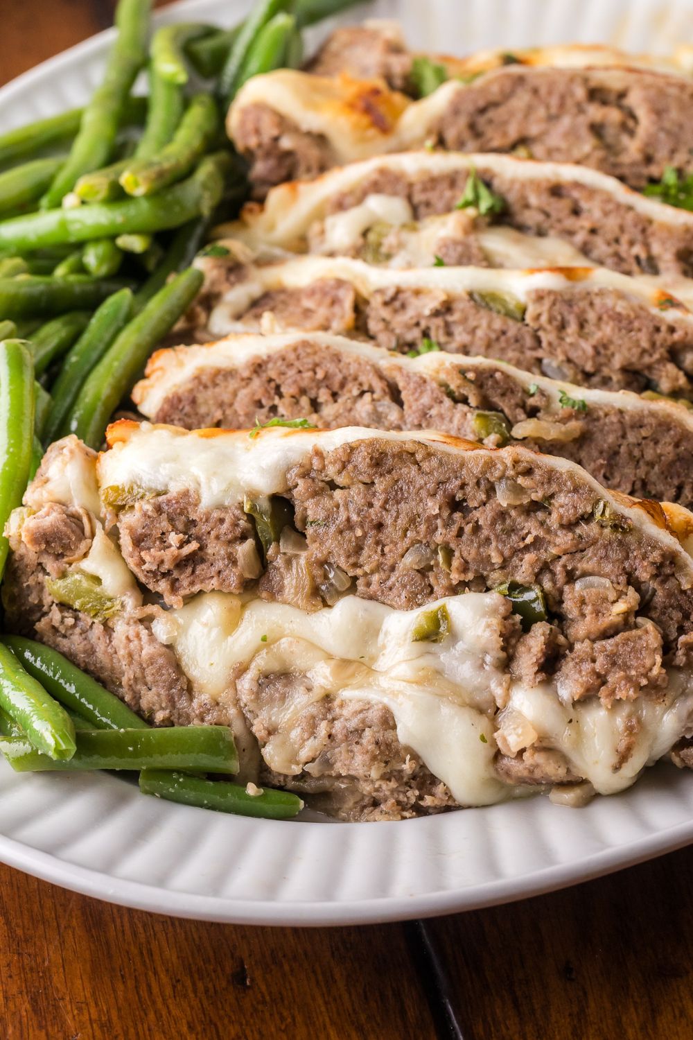 platter with greens on it, and then topped with sliced Stuffed Philly Cheesesteak Meatloaf  