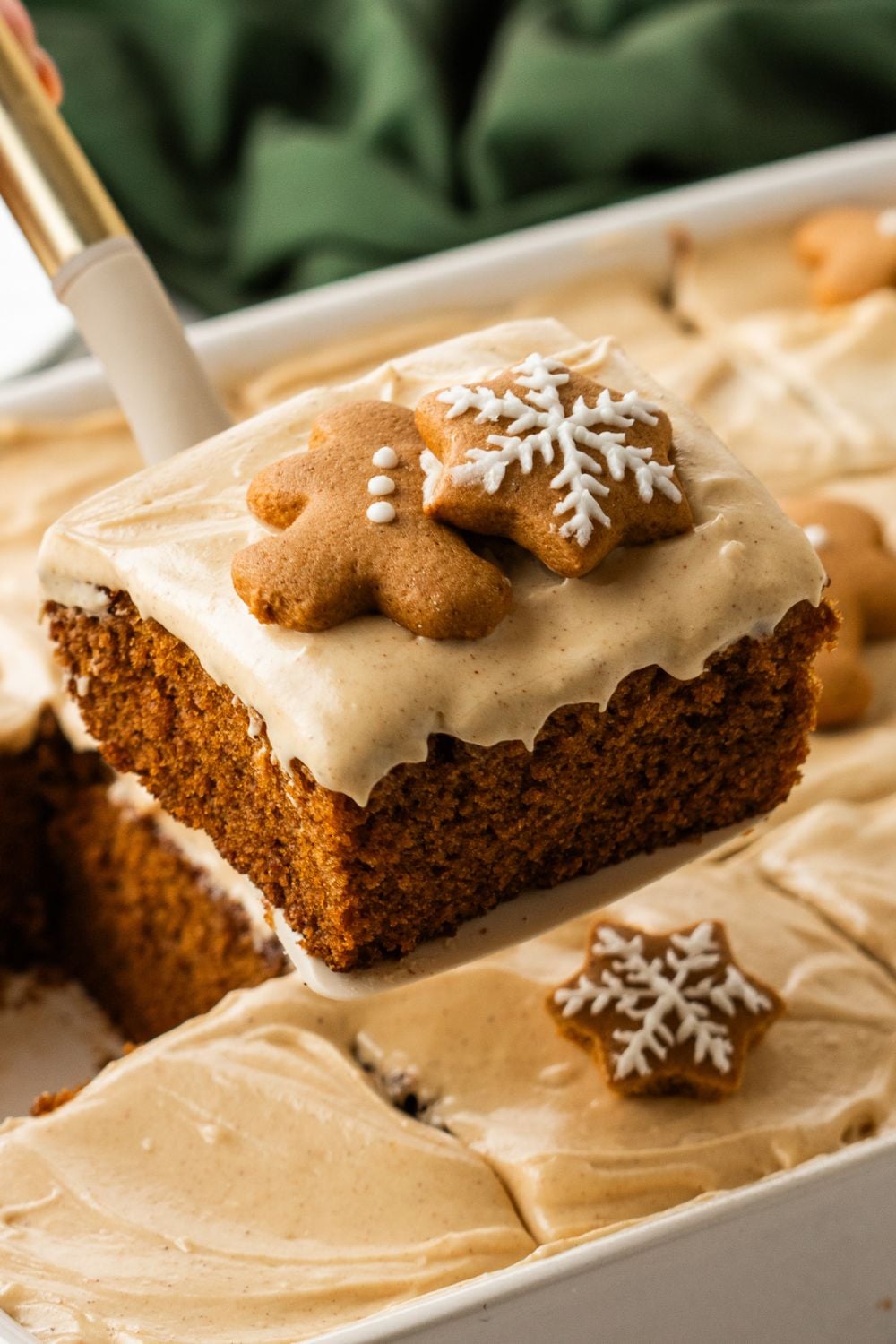 Gingerbread Cake with Cream Cheese Frosting in pan with a slice of cake lifting out of pan 