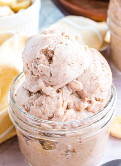 Banana Ice Cream in a glass bowl on table with slices of bananas around table