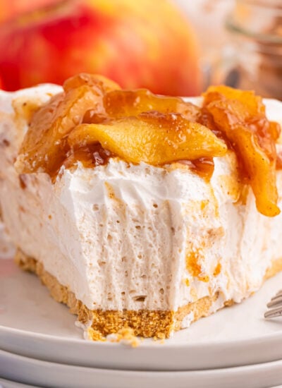 No Bake Apple Cheesecake slice on a stack of white serving plates