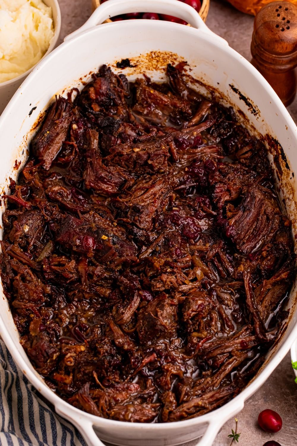 overhead look of casserole dish with shredded Cranberry Pot Roast in it 