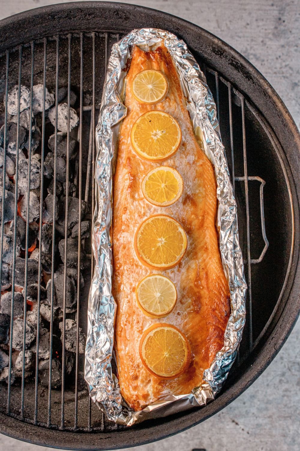 charcoal grill with Grilled Honey Mustard Salmon in Foil on top of rack 