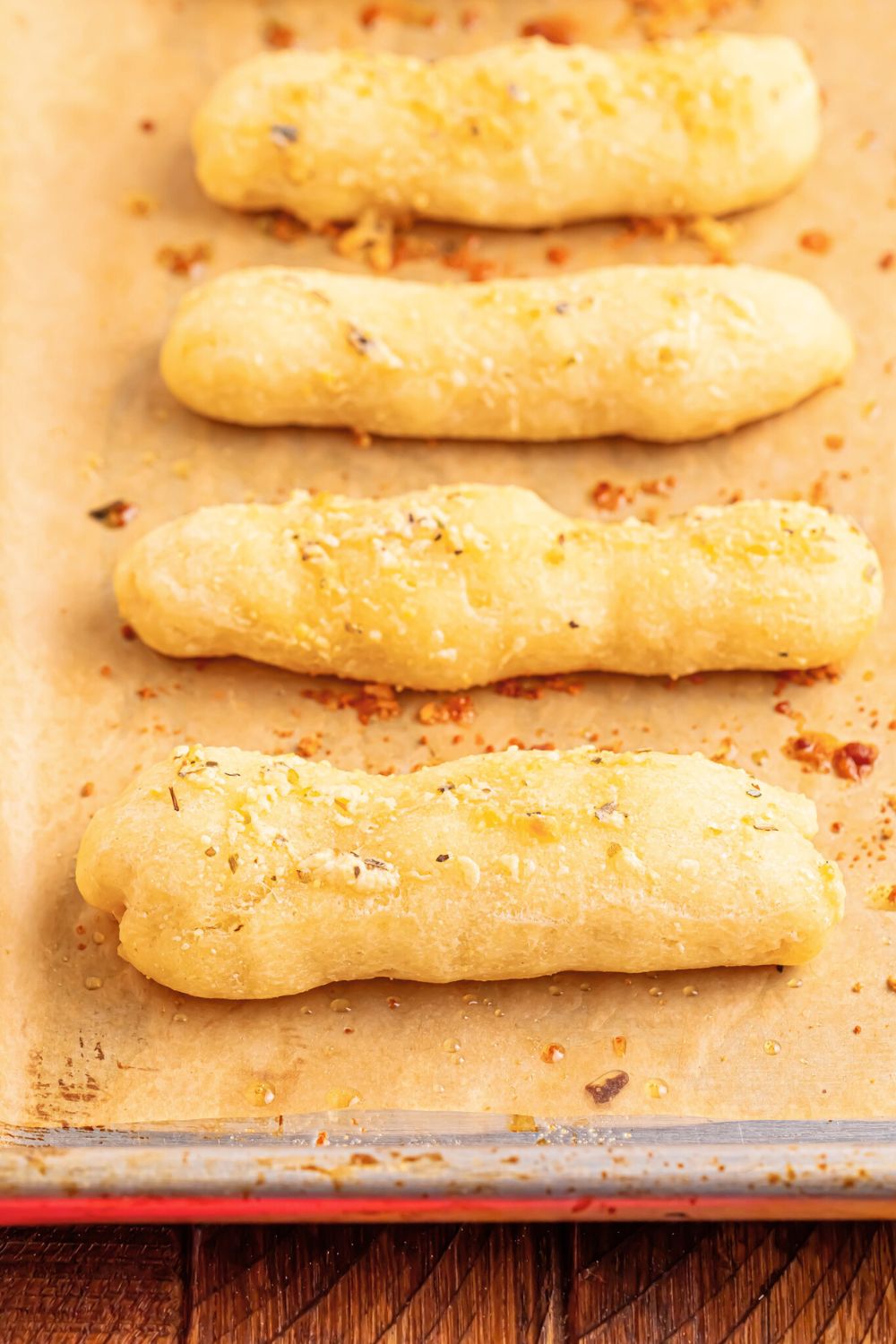 baking sheet with 2 Ingredient Garlic Parmesan Breadsticks spread out in a single layer 