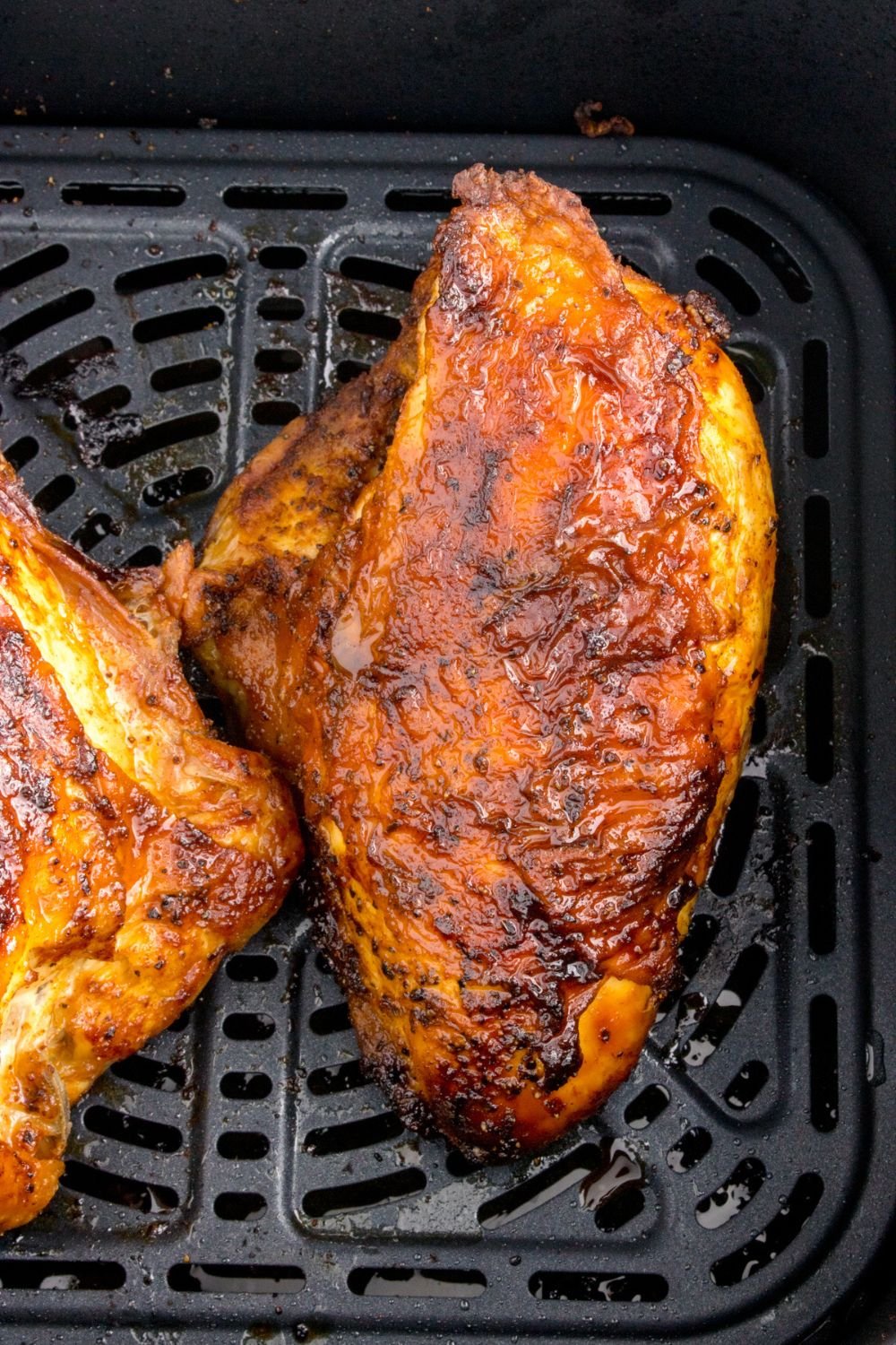 Air Fryer Chicken Breast cooked and in an air fryer basket 
