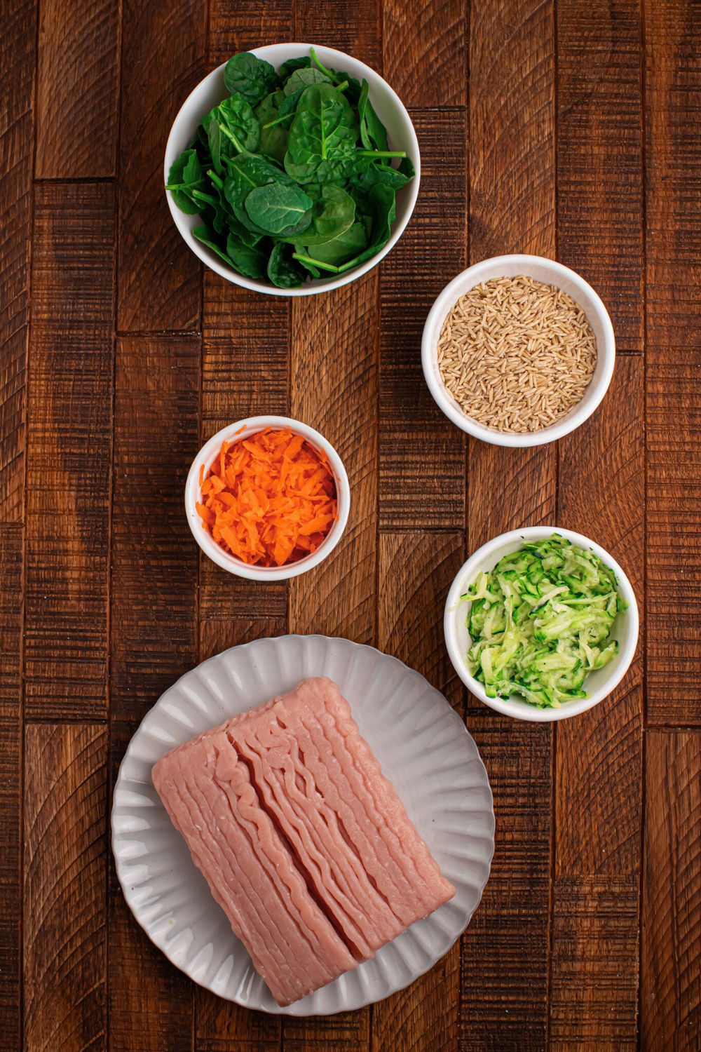 ingredients for making Homemade Turkey and Rice Dog Food with Veggies in single serve containers sitting on a wooden table 