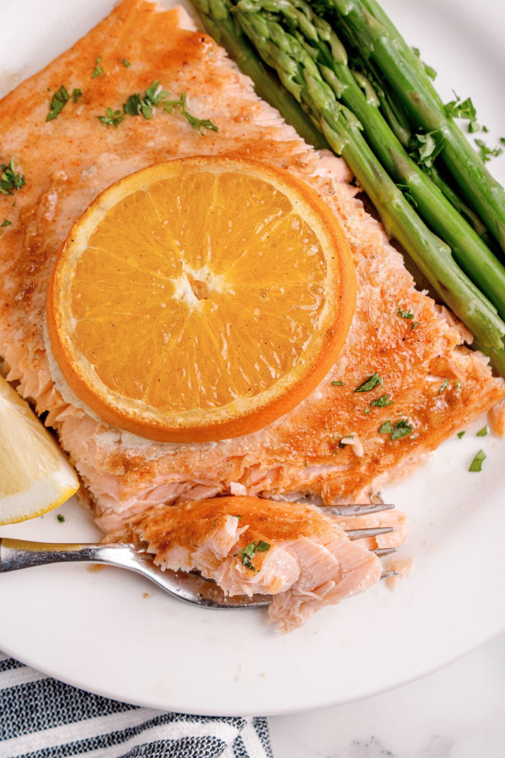 plate with grilled honey mustard salmon with orange slice on top and veggies to the side 