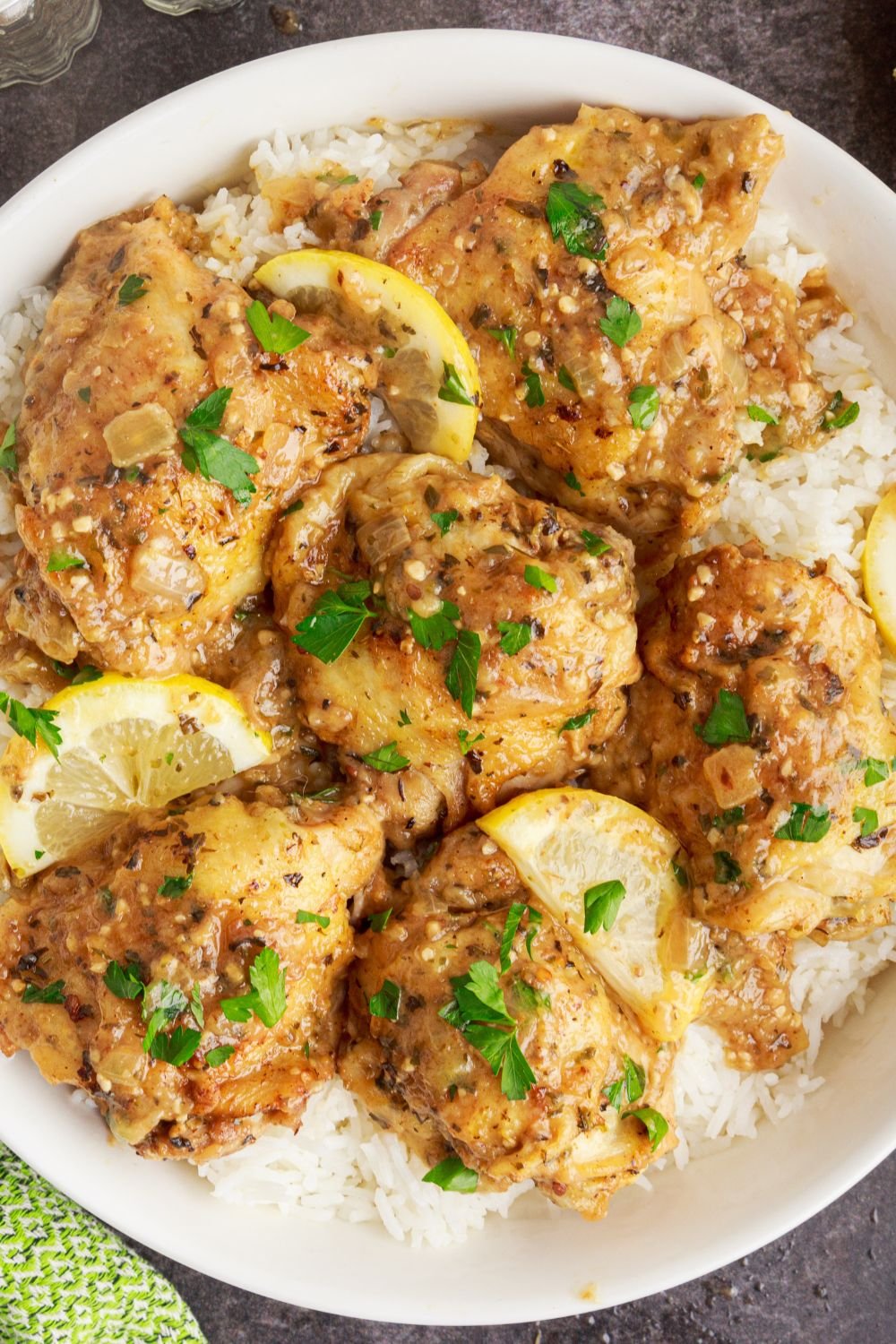 Instant Pot Lemon Butter Chicken on plate with rice under it and parsley sprinkled on top 
