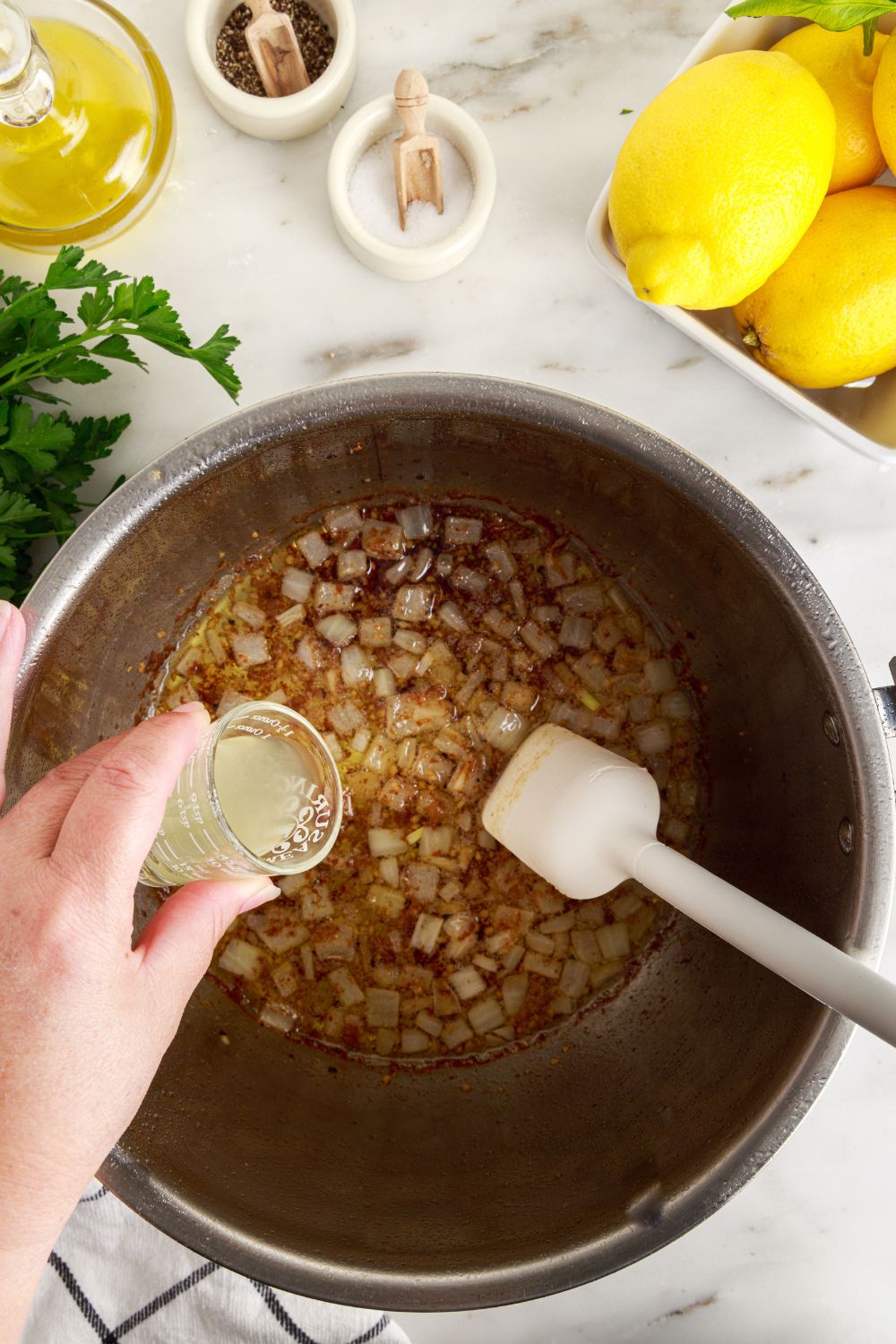 onions sauting in instant pot with some sauce being poured into the pot 