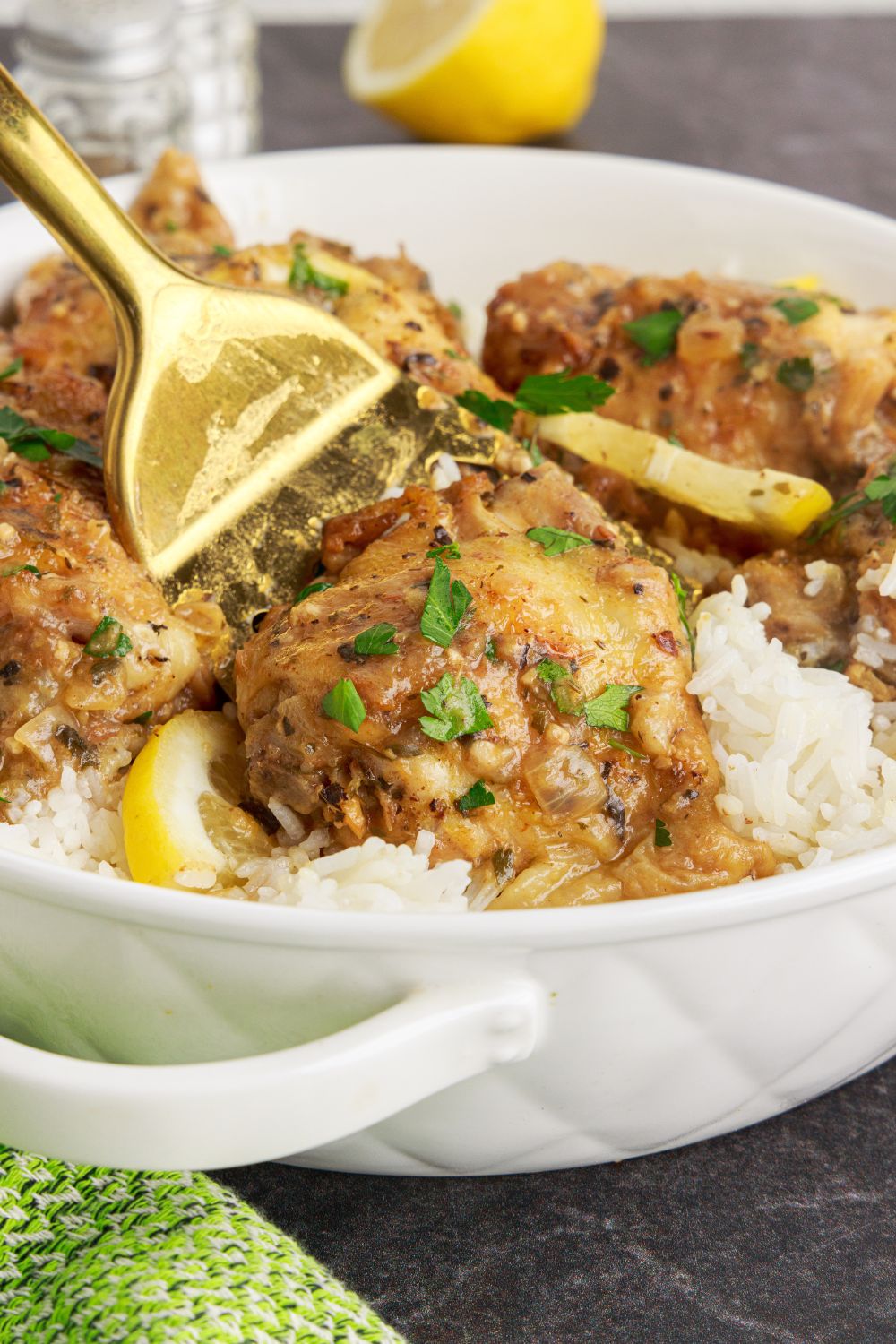 Instant Pot Lemon Butter Chicken in a bowl with a fork poking into a piece of the chicken 