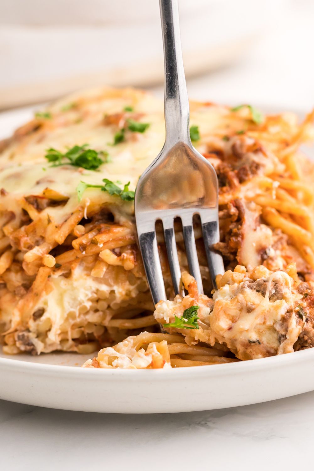 Million Dollar Spaghetti Casserole on a plate with a fork in it 