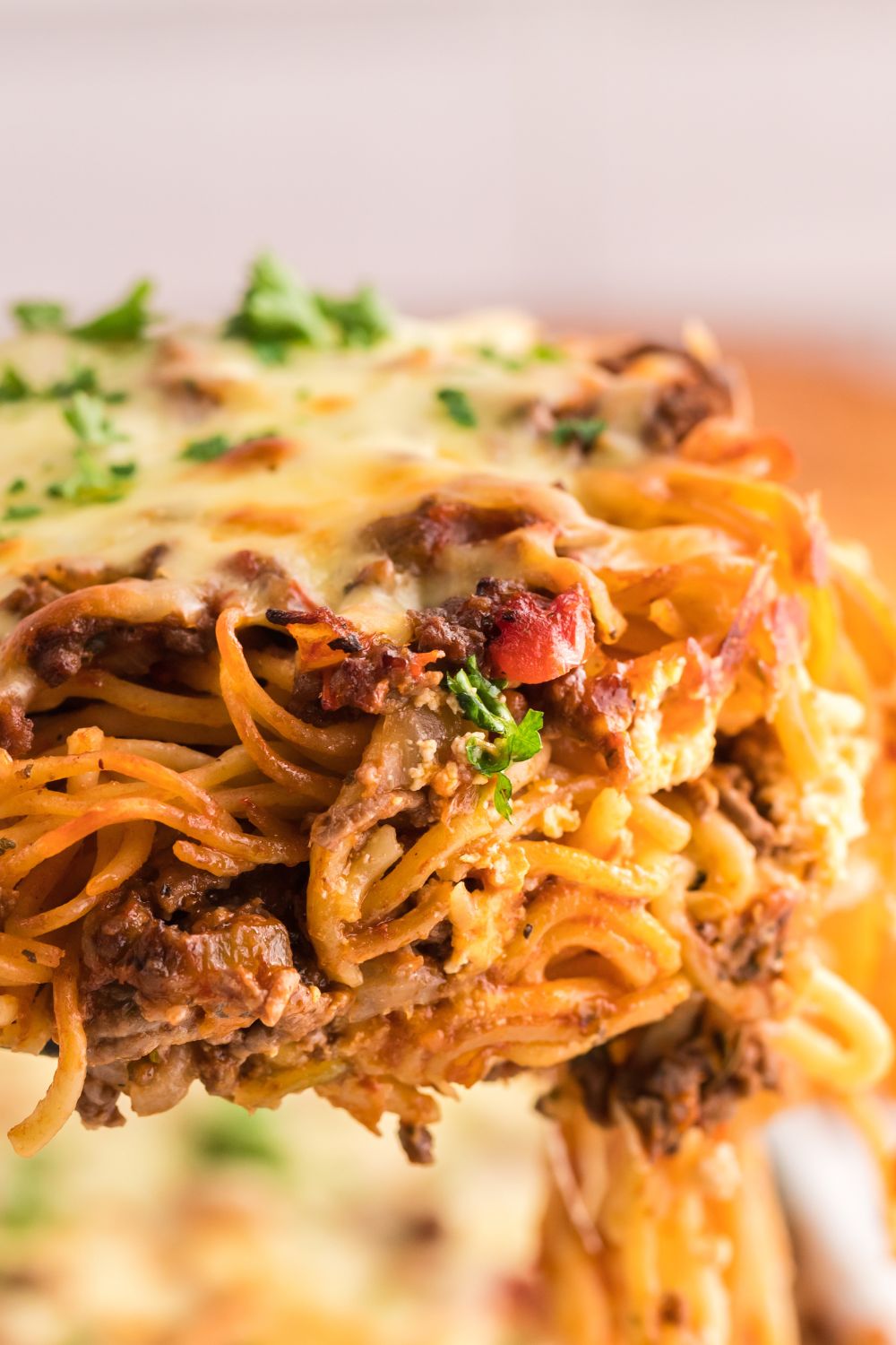 lifting up Million Dollar Spaghetti Casserole from the pan 