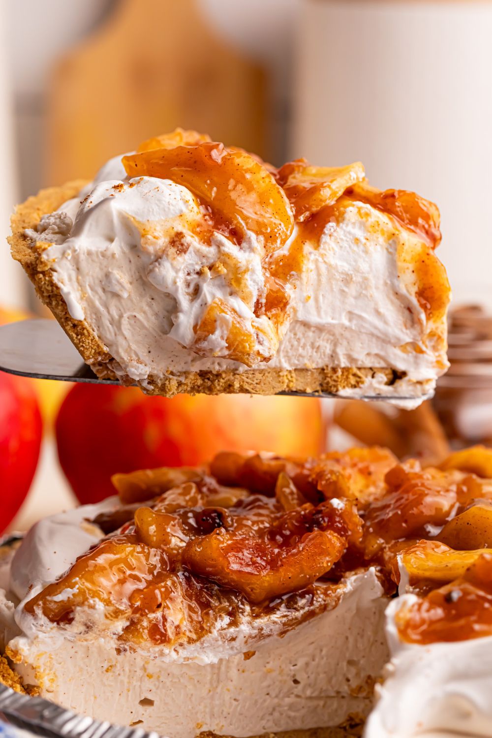 No Bake Apple Cheesecake pie being lifted out of pie plate with spatula 
