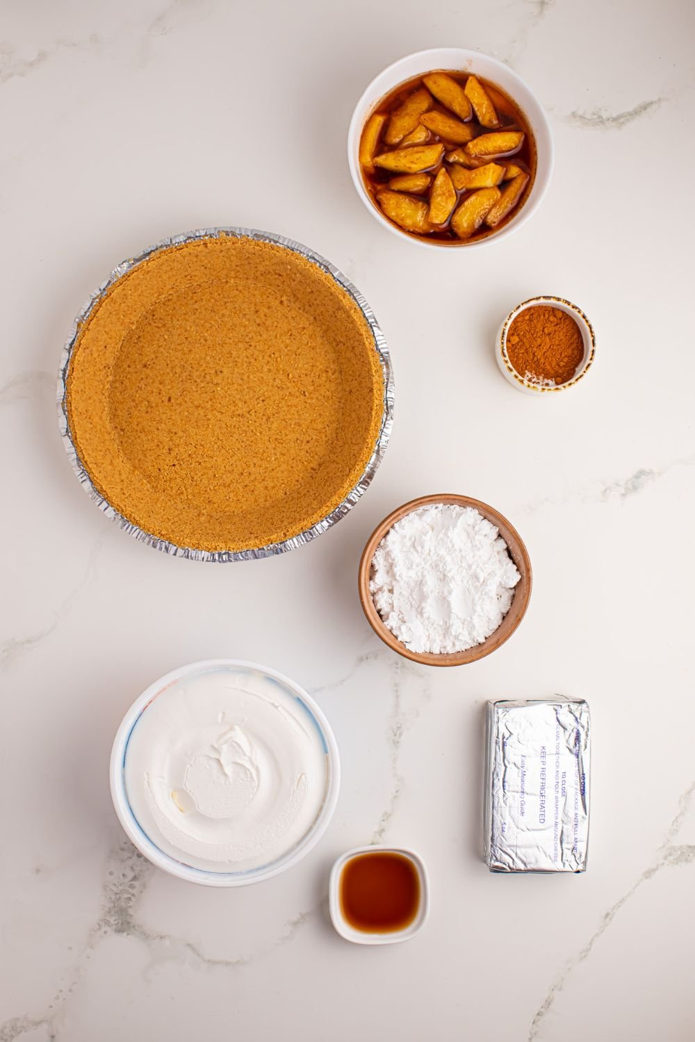 ingredients for No Bake Apple Cheesecake pie in single serve containers on table 