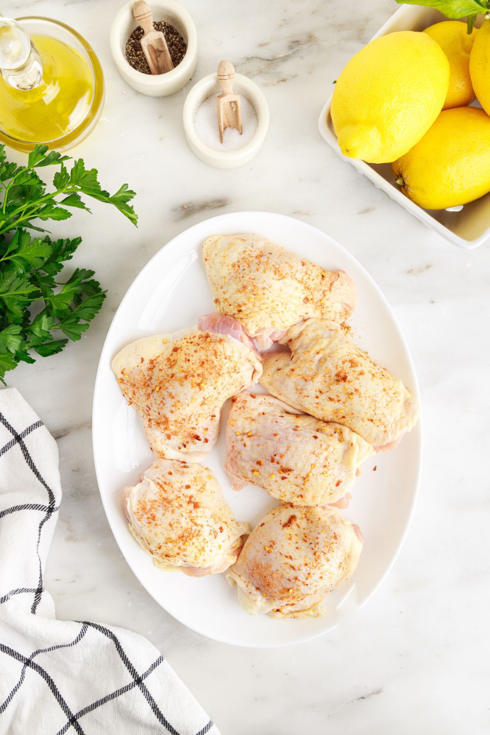 raw chicken on plates with parsley and other ingredients around the table