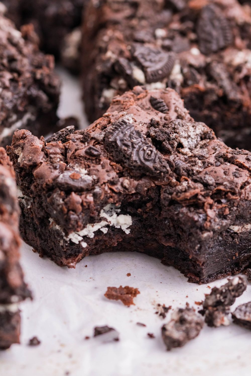 Oreo Stuffed Brownies on table with a bite taken out of one of the brownies
