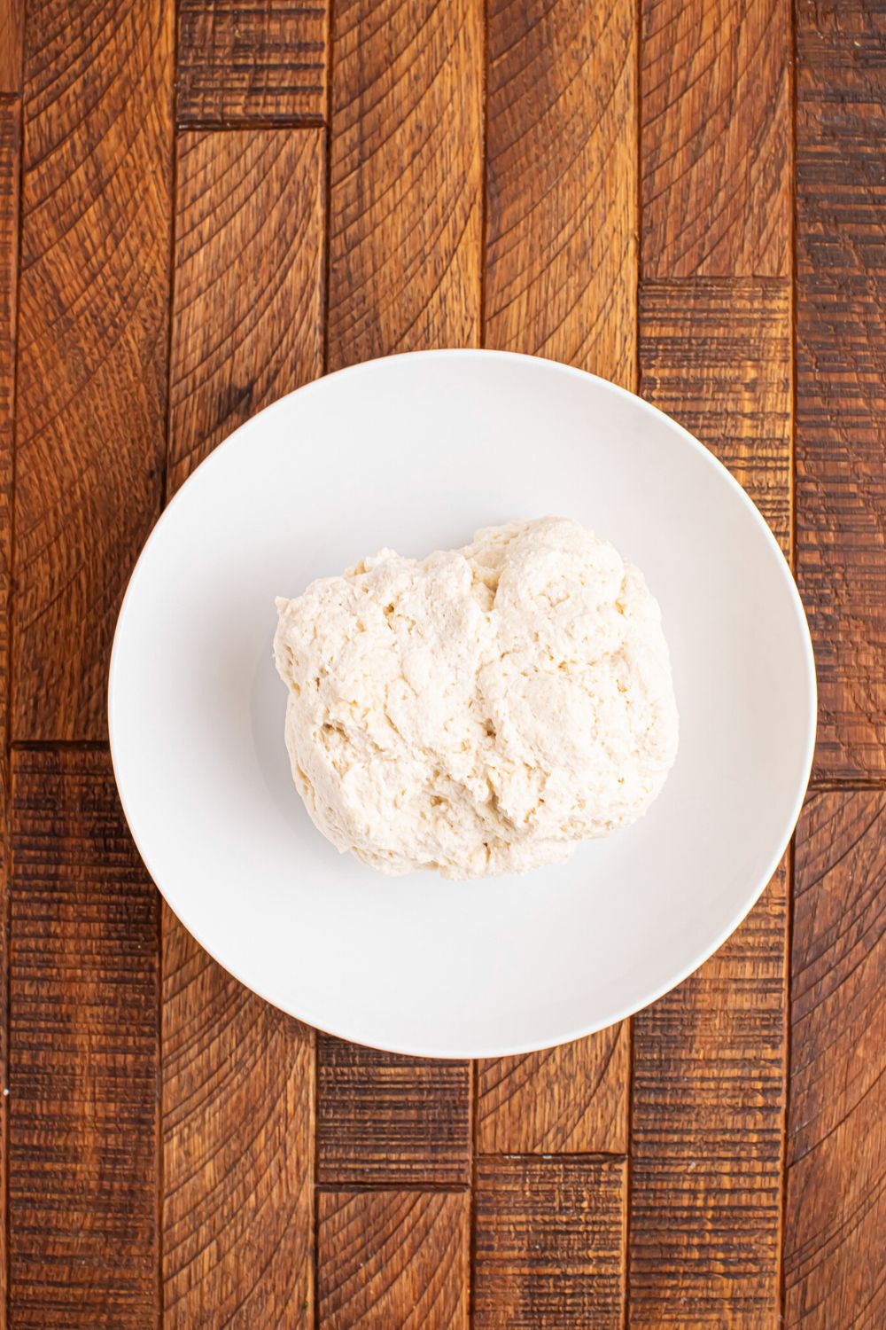plate with a big ball of 2 Ingredient Garlic Parmesan Breadsticks dough on table