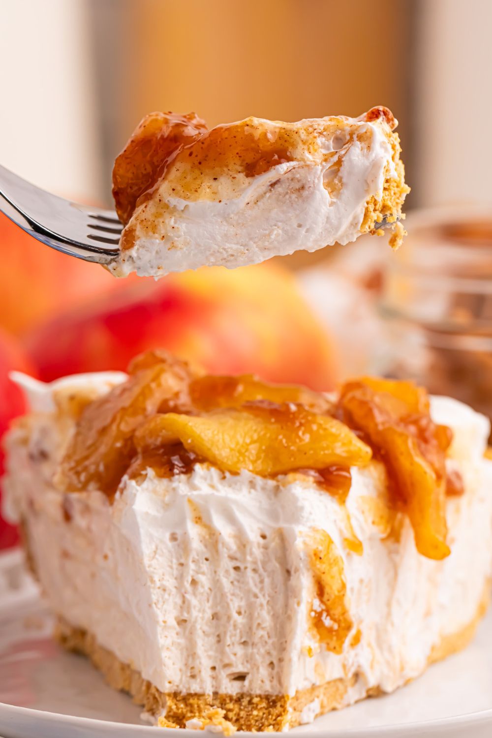 plate with a slice of No Bake Apple Cheesecake pie and a fork with one bite on fork 