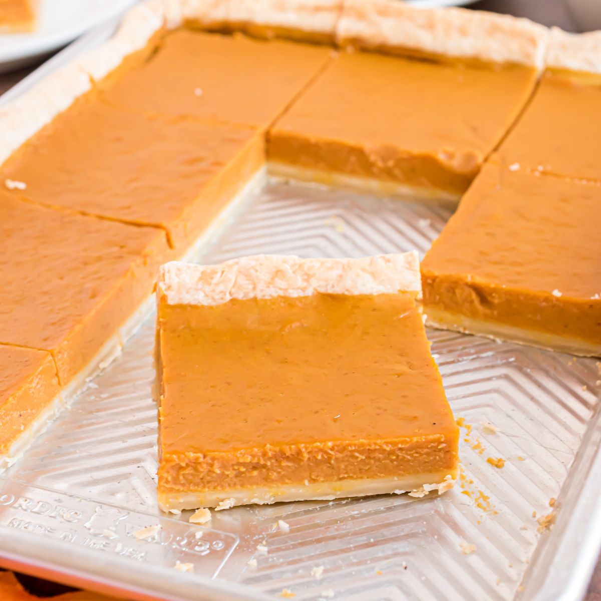 metal sheet pan sitting on table with a few slices of the pie gone to show how many slices of pie you get out of this slab pie recipe 