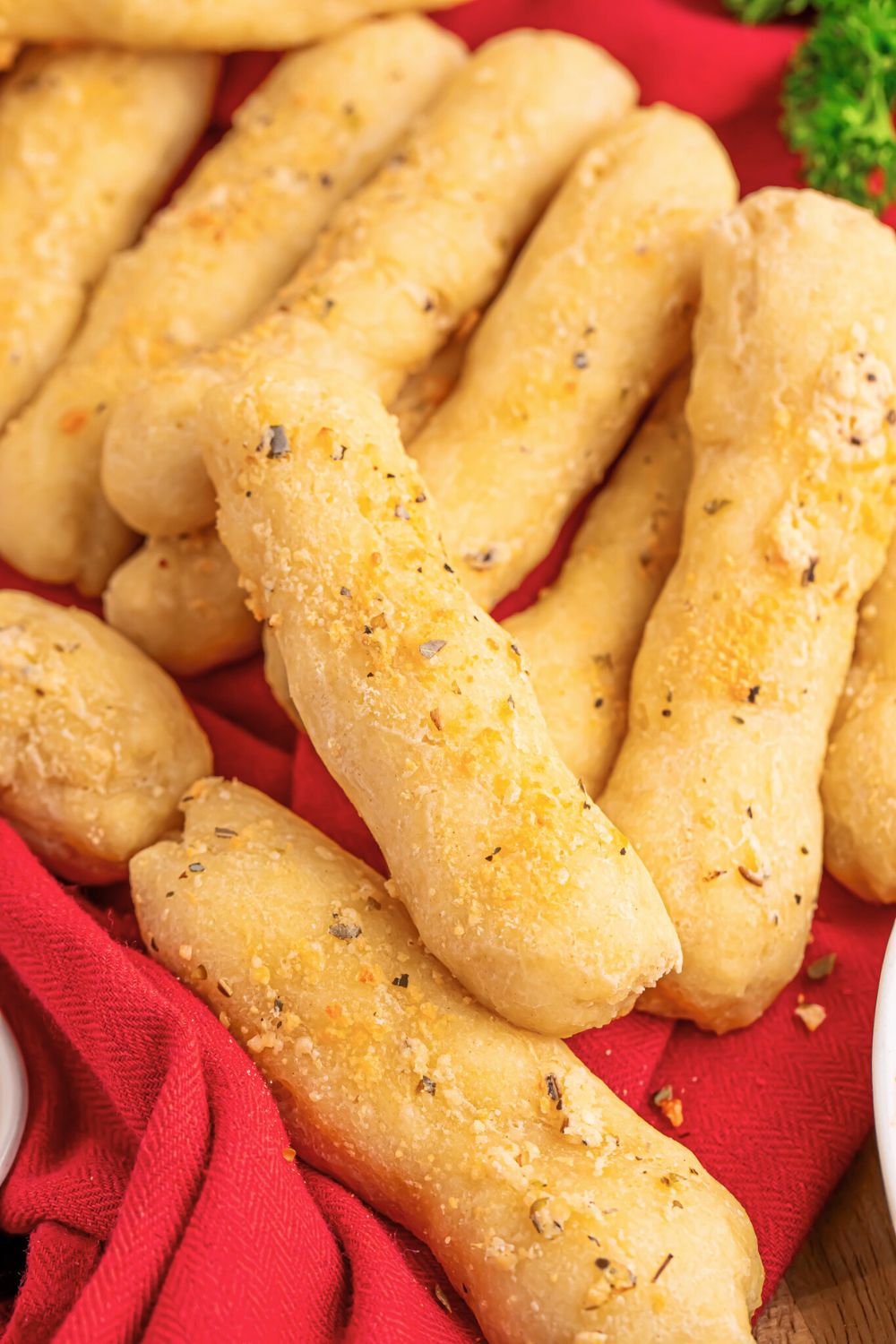 view of table full of 2 Ingredient Garlic Parmesan Breadsticks scattered around 