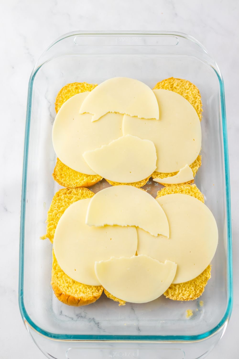 rolls with provolone cheese spread over the top of the buns 