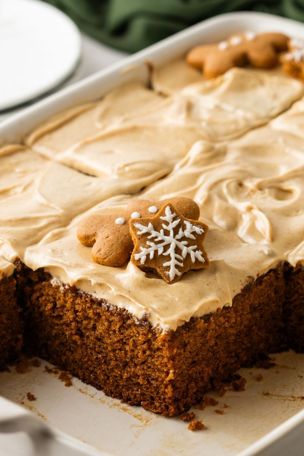 close up of pan with Gingerbread Cake with Cream Cheese Frosting in it with a handful of pieces missing in pan 