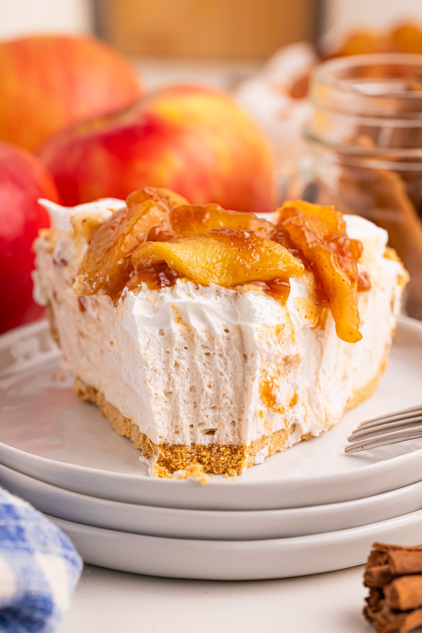 Slice of the No Bake Apple Cheesecake pie on a stack of small white serving plates