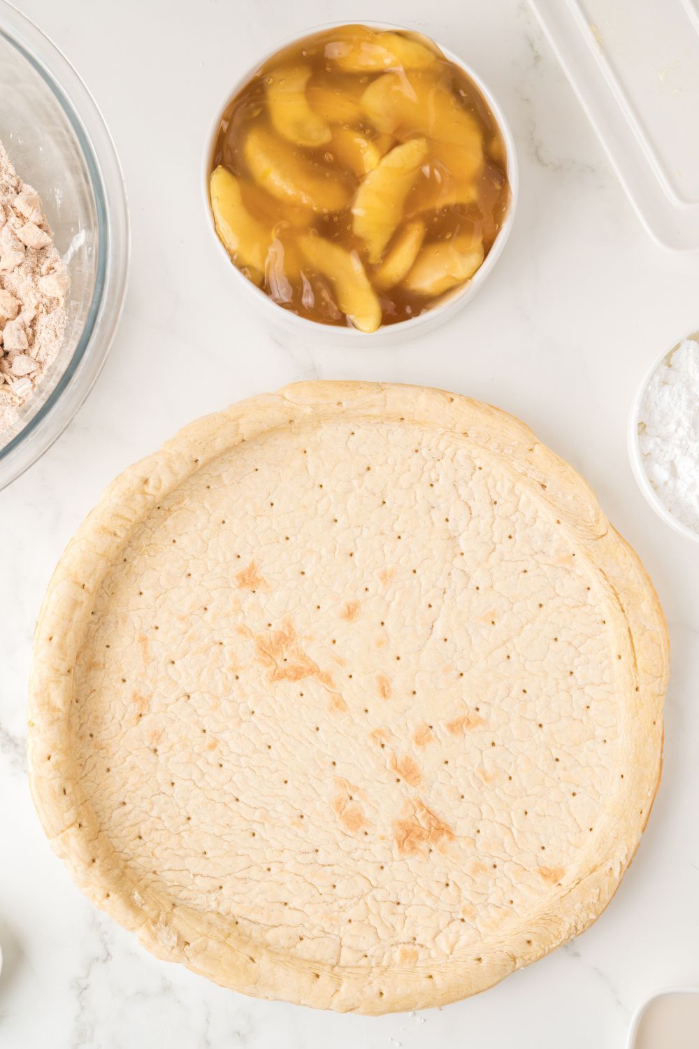 Apple Pie Pizza ingredients placed around table in containers 