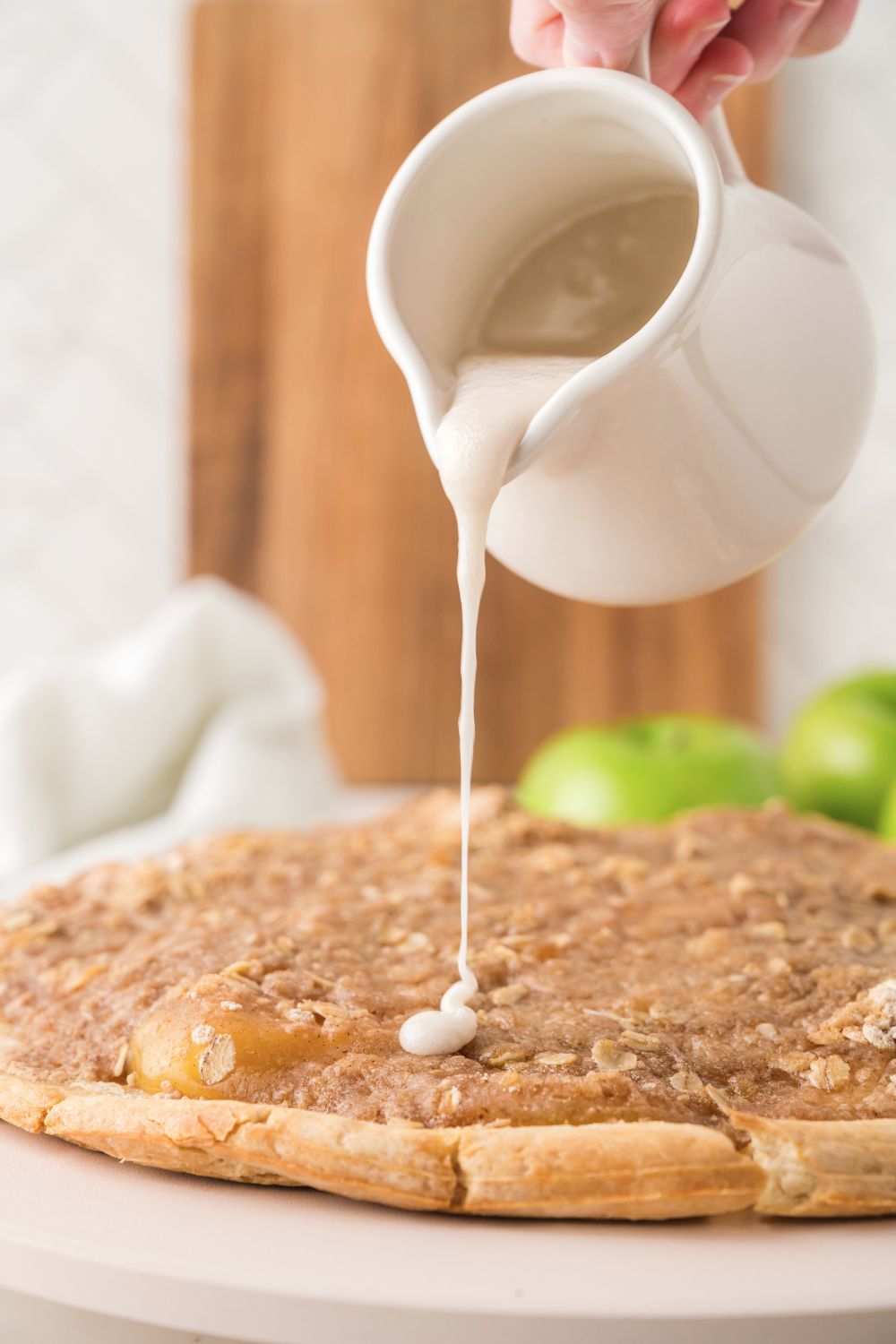 drizzle of glaze on top of Apple Pie Pizza on table 