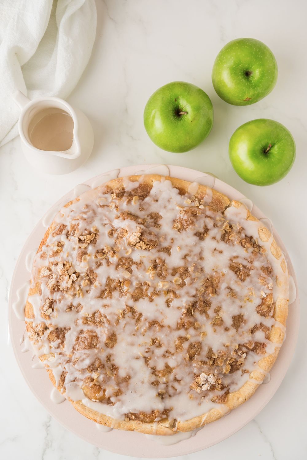Apple Pie Pizza on table with some green apples to side 