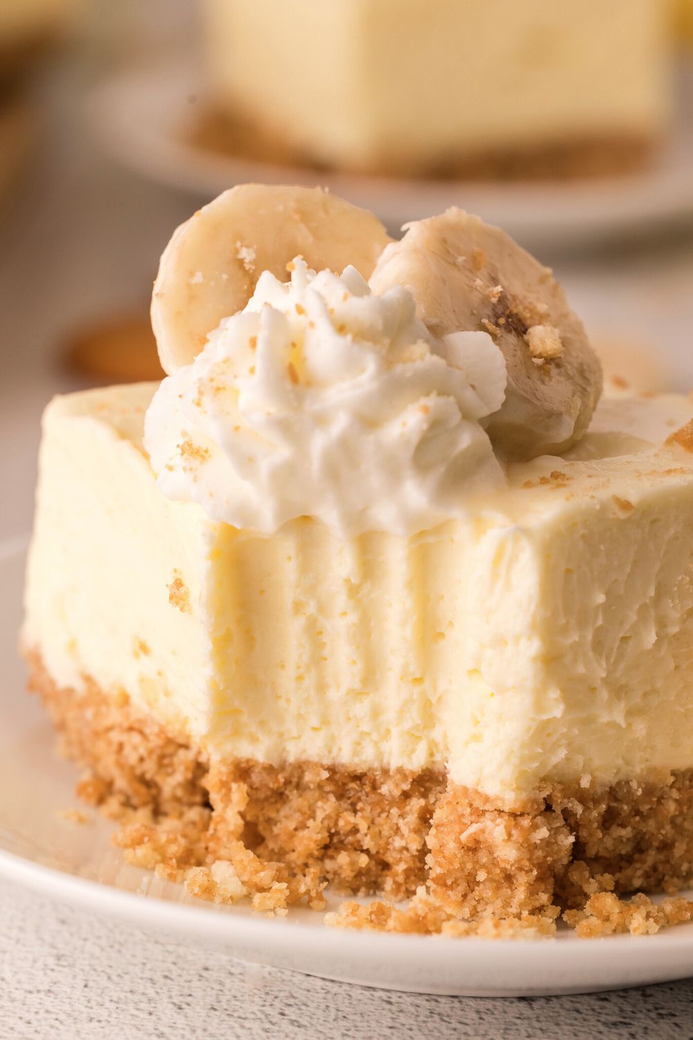 No Bake Banana Pudding Cheesecake Bar on plate with a bite taken out of it 