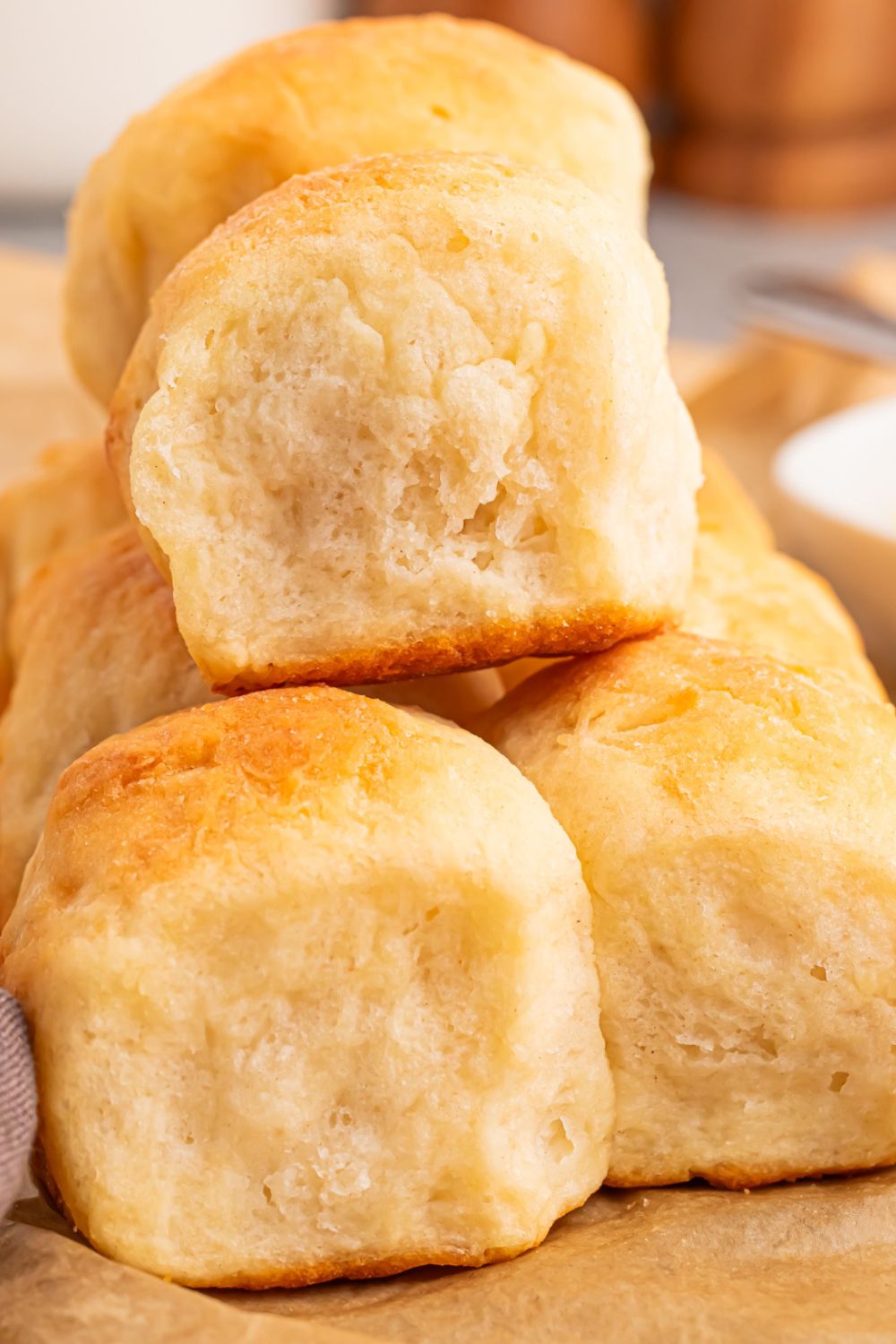 2 Ingredient Dinner Rolls stacked on table with salt and pepper behind it 
