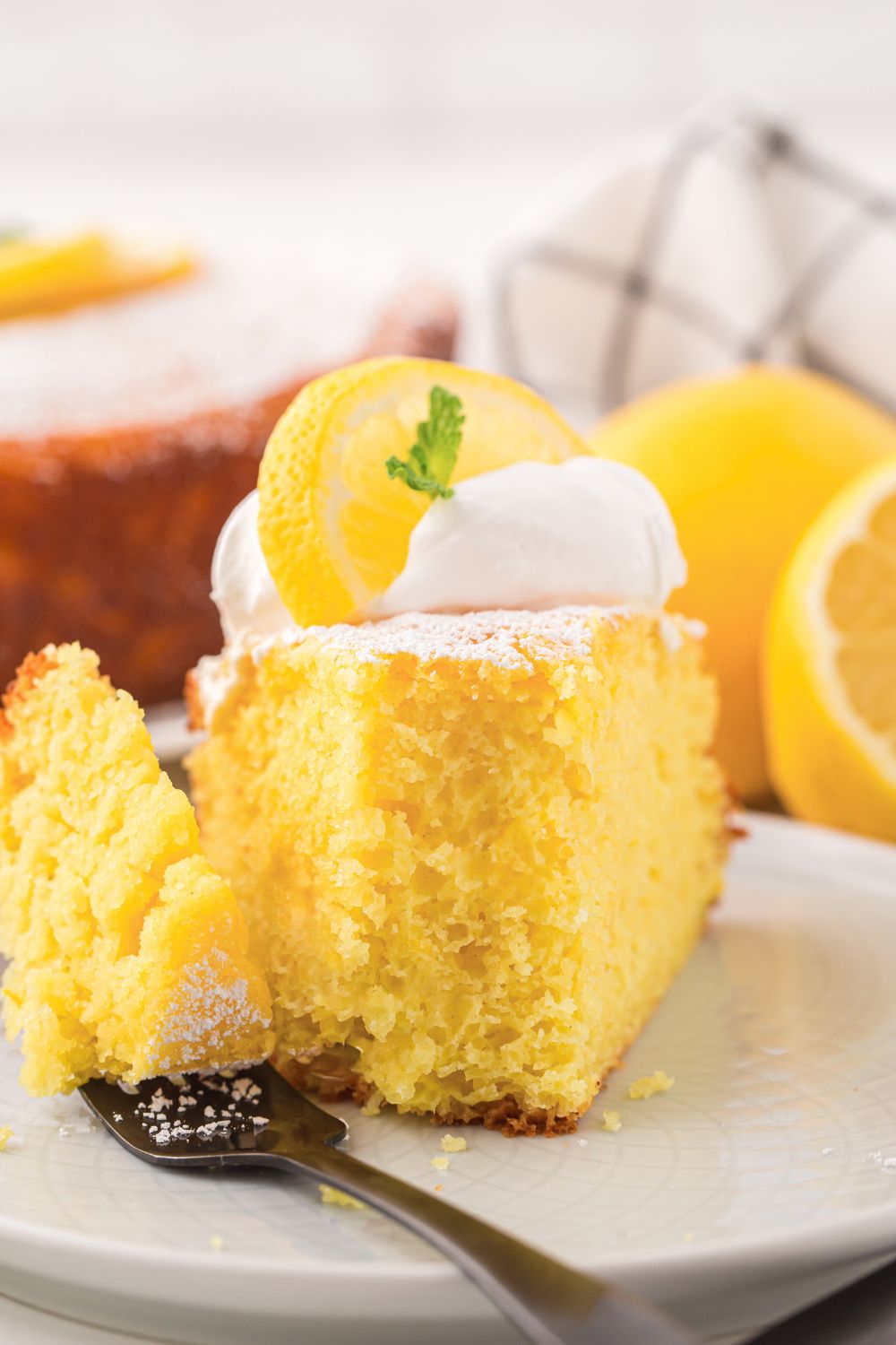 Italian Lemon Ricotta Cake on plate with a bite taken out of the slice 