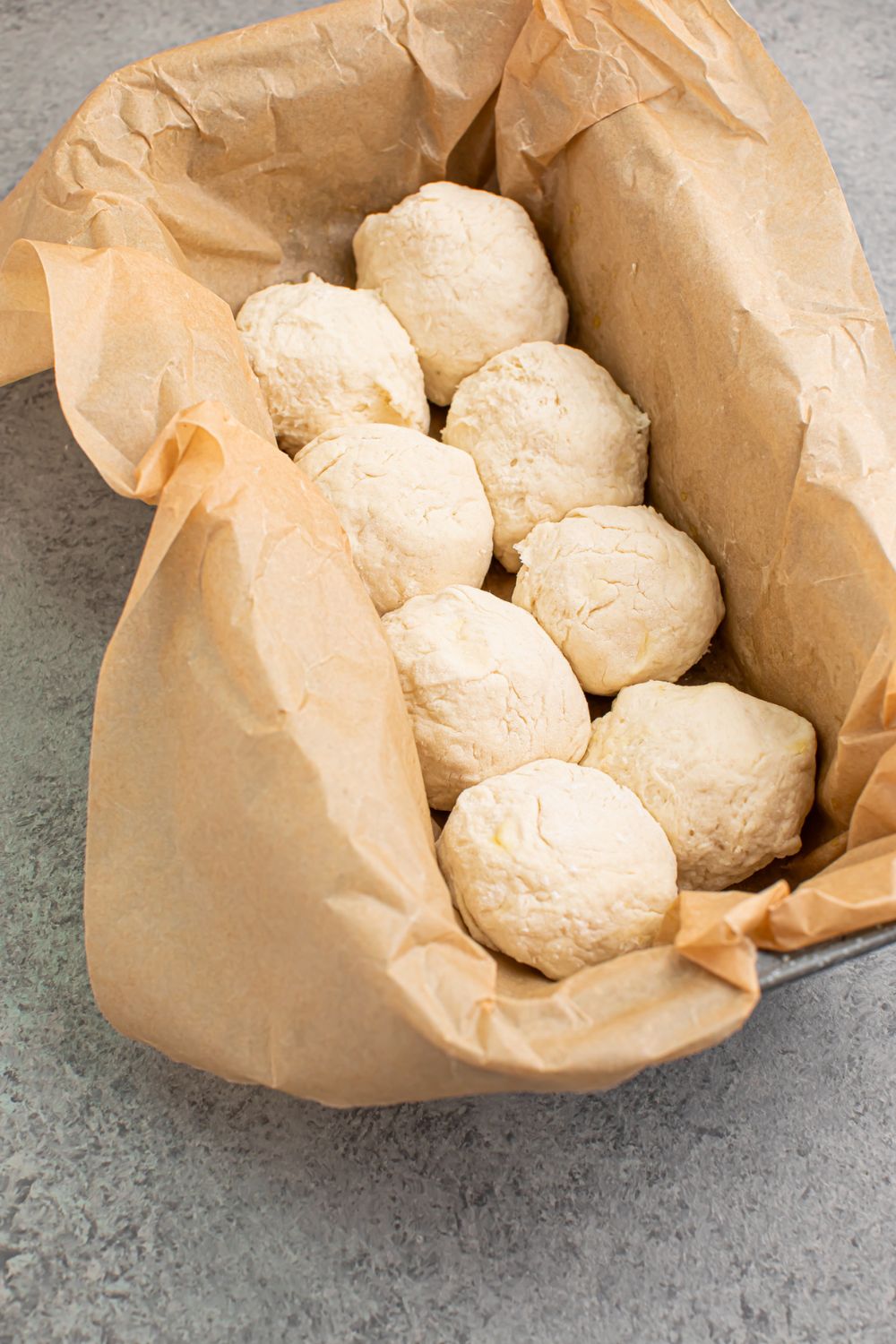 raw 2 Ingredient Dinner Rolls in pan with parchment paper 