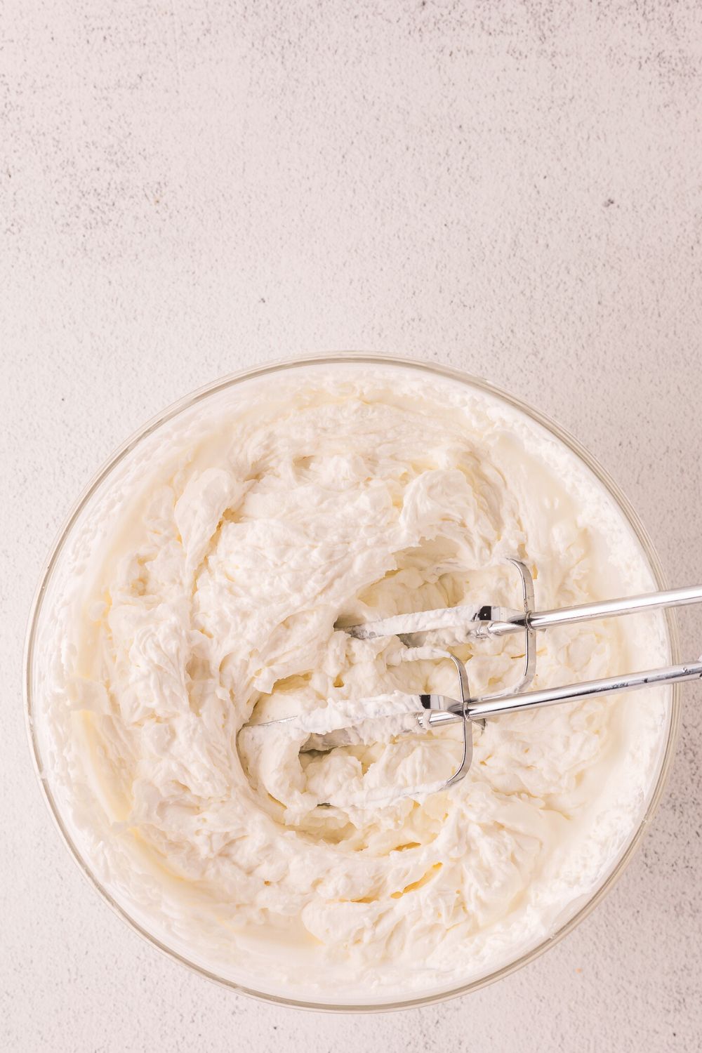 bowl with the start of a cheesecake batter being mixed in pan 