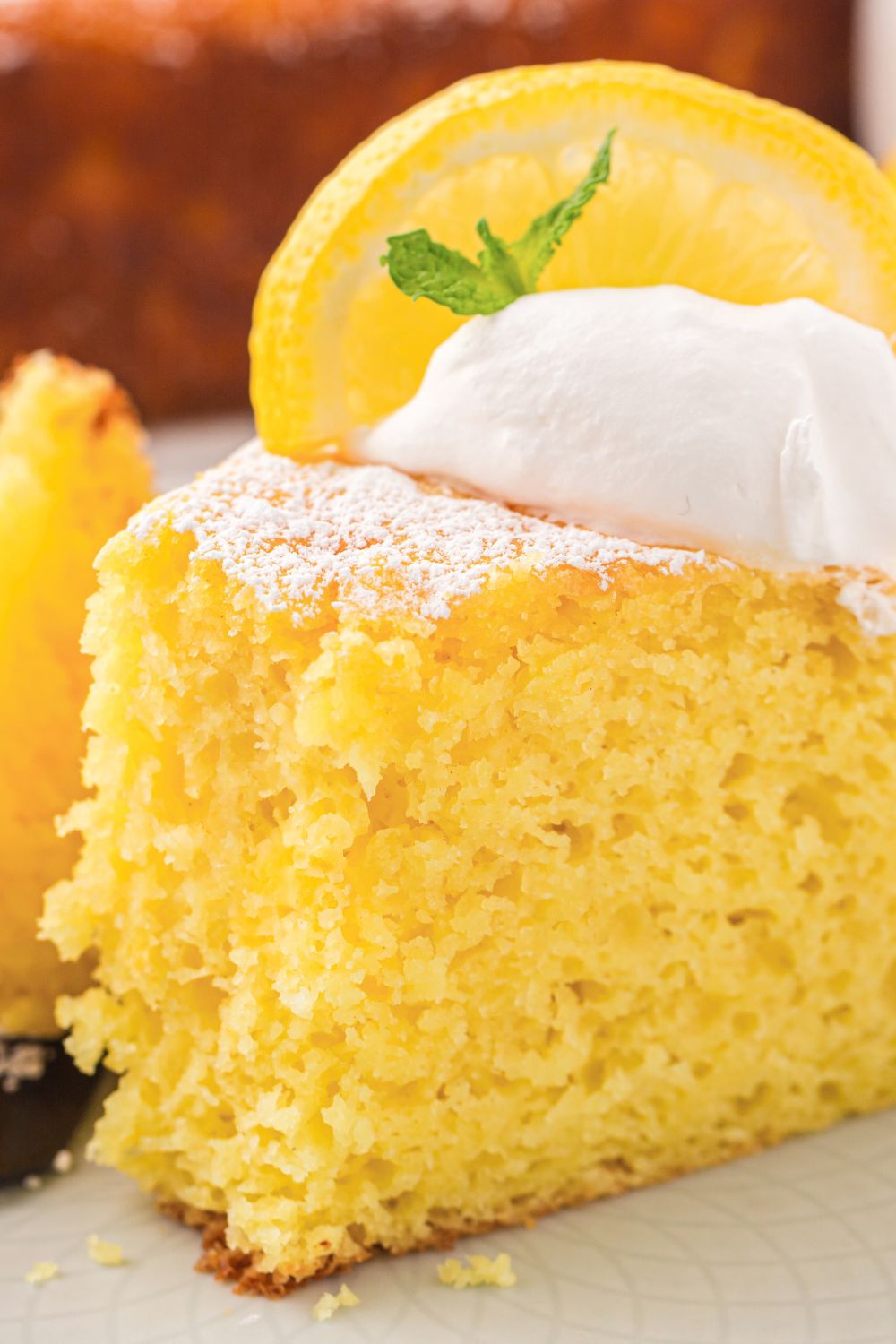 close up of Italian Lemon Ricotta Cake with a bite taken out of the front of the cake on plate 