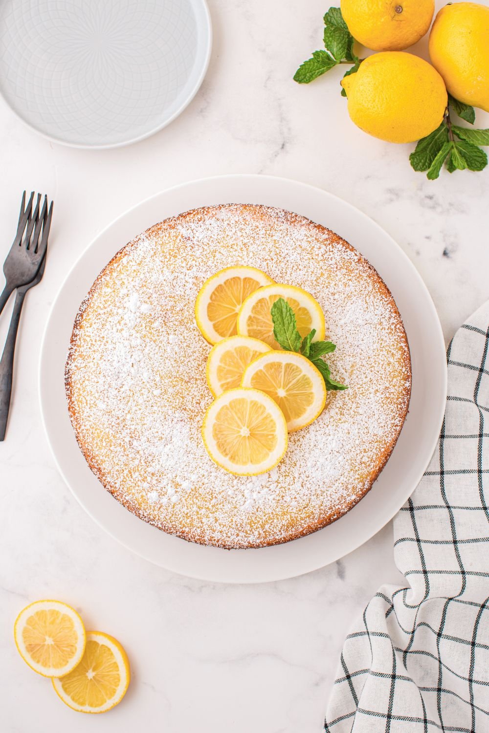 Italian Lemon Ricotta Cake on a table sprinkled with powdered sugar 