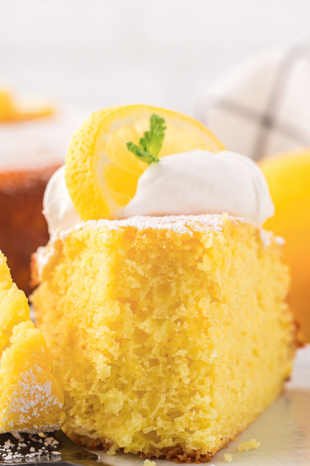 slice of Italian Lemon Ricotta Cake with a fork bite taken out of it on a plate on table 