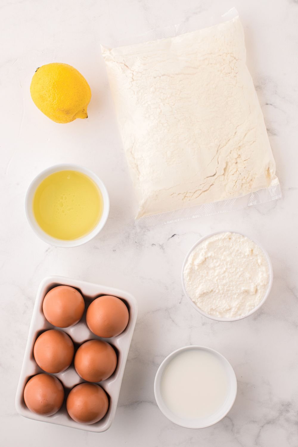 ingredients for the Italian Lemon Ricotta Cake in single serve containers on table 